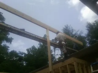 Carpenter setting a ridge beam over a new addition frame — Ice Dam Removal by Roofing Brothers in Tamiment