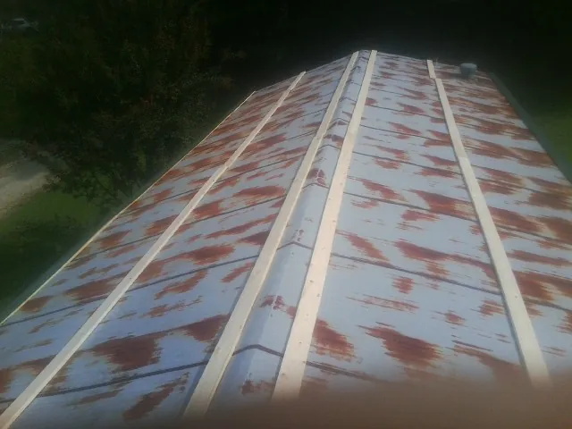 Rusted metal roof panels with new wood purlins before replacement — Storm Damage Roof Repair in Tamiment by Roofing Brothers