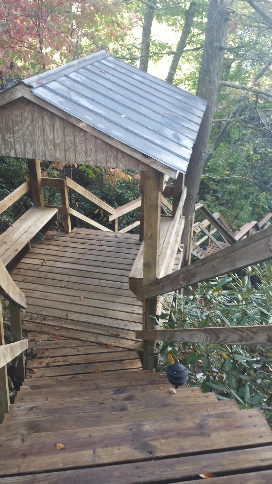 Metal roofed shelter over wooden steps on a wooded walkway — Skylight Repair & Installation work by our crew in Tamiment
