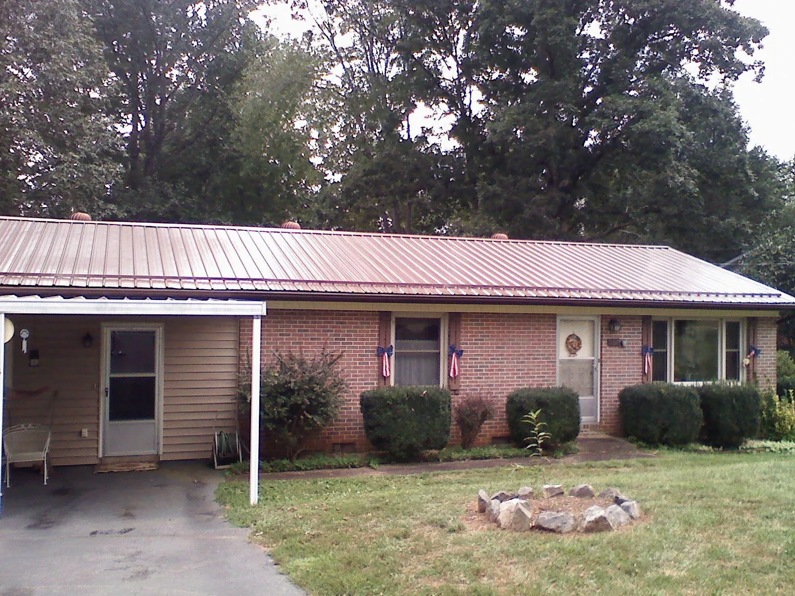 Bronze metal roof and carport on a brick ranch home — Roof Repair work by our crew in Tamiment